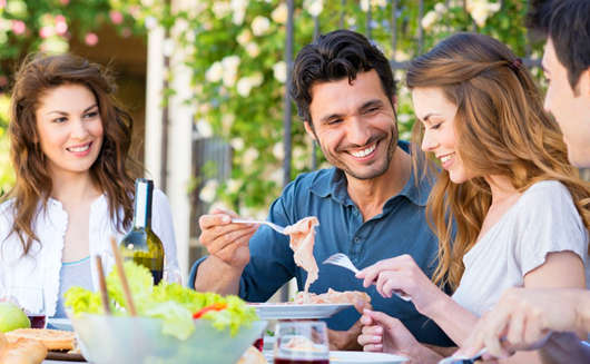 Group-Of-Happy-Young-Friends-Having-Dinner-At-Patio.jpg